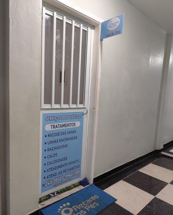 Porta da clínica na sala 310 com a lista de serviços podológicos
